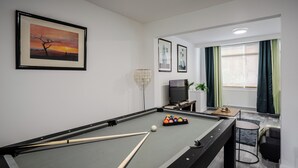 A pool table with balls and cues, a television, and framed artwork on the wall. - 3 Bedroom House - Pool Table, Opp Train Station (Manchester)