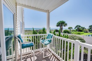 Ein Balkon mit zwei Stühlen und Blick auf den Strand.