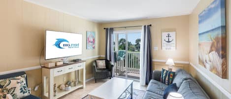 Un salon équipé d’un téléviseur, d’un canapé, d’une table basse et d’un balcon avec vue.