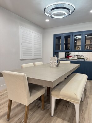 A dining area with a rectangular table, six chairs, and a bench.