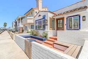 A residential building with a balcony, a small pool, and a patio area. - Charming 2BR Bungalow Steps from the Beach with Fire Pit (Newport Beach)