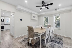 A dining area with a table, chairs, and a ceiling fan. - North End 11BR - Walk to Beach & Boardwalk, Sleeps 26! (Ocean City)
