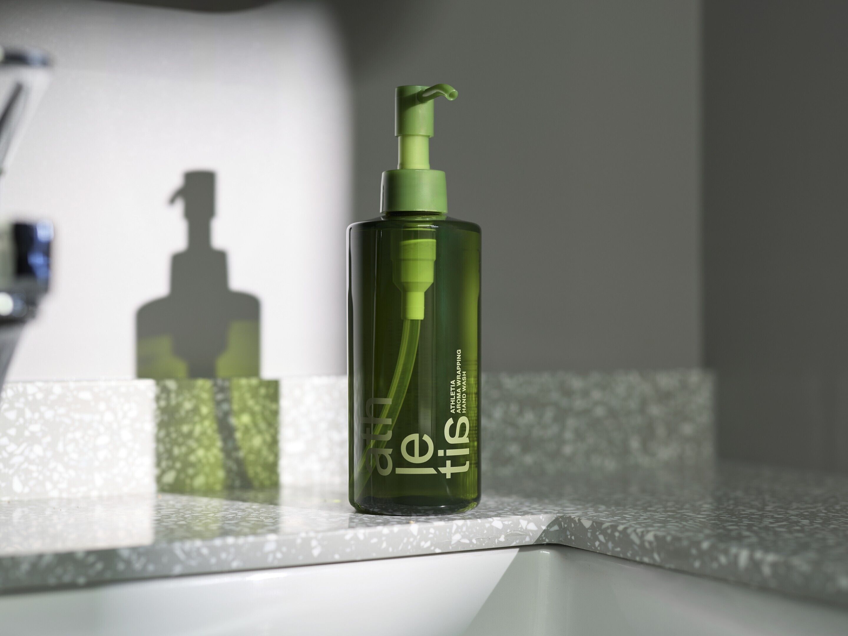 A green bottle with a pump dispenser on a countertop.