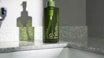A green bottle with a pump dispenser on a countertop.