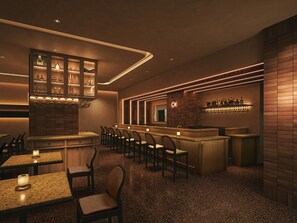 Un'area bar con posti a sedere e un bancone, caratterizzata da un design moderno e illuminazione d'atmosfera.