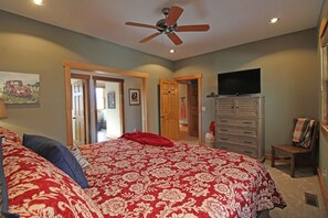 A bedroom with a large bed, a ceiling fan, a dresser, and a television. - Haven in the Woods- Luxury Rental in the Heart of Bryson City, NC (Bryson City)