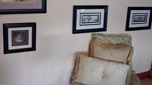 Una pared con obras de arte enmarcadas, un sofá estampado y un enchufe.