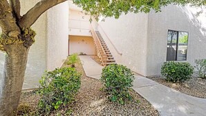 A building with a staircase leading to an upper level, surrounded by small bushes and a tree. - Prime location deluxe condo with pool and hot tub in beautiful Phoenix (Phoenix)