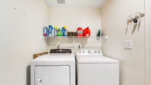 A laundry area with two washing machines and a shelf with cleaning supplies. - Prime location deluxe condo with pool and hot tub in beautiful Phoenix (Phoenix)