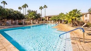 A swimming pool with lounge chairs and palm trees. - Prime location deluxe condo with pool and hot tub in beautiful Phoenix (Phoenix)