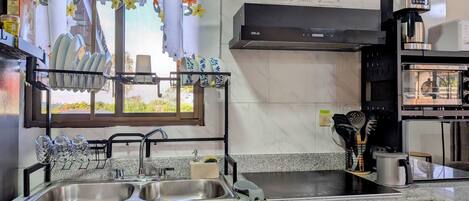 A kitchen with a double sink, a coffee maker, and a microwave.