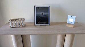 A framed poster of Villa Yisel, a wooden table with a woven basket, and a small sign.