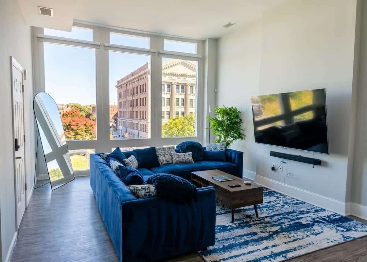 A modern living room with a sectional sofa, a coffee table, and a flat-screen TV.
