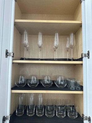 A cabinet with shelves holding various glassware. - Huge Downtown home w/parking 4 bdrm Penn Station (Baltimore)