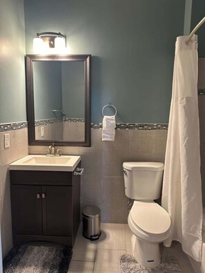 A bathroom with a sink, toilet, and mirror. - Huge Downtown home w/parking 4 bdrm Penn Station (Baltimore)