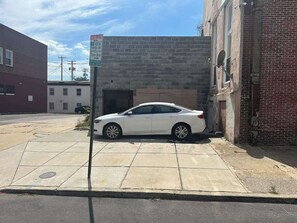 A white car parked in front of a building with a 'No Stopping' sign. - Very large! Penn Station Downtown home w/parking (Baltimore)