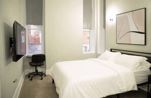A bedroom with a bed, a chair, a TV, and a window. - Very large! Penn Station Downtown home w/parking (Baltimore)