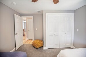 A bedroom with a bed, a wardrobe, and a door leading to another room. - Serenity Point- Shellcamp Lakefront- 4bd3.5bth-Mountain Views- Pet Friendly! (Gilmanton)