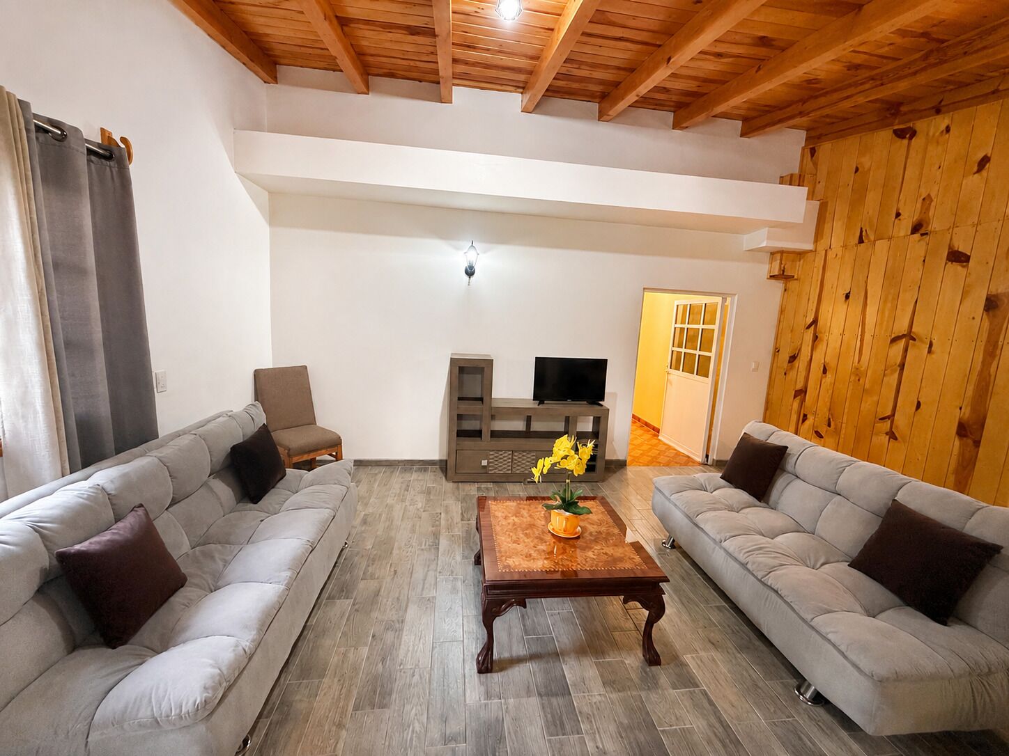 A spacious living room with two sofas, a coffee table, and a TV stand.
