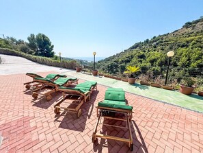 Eine Dachterrasse mit Liegestühlen und Topfpflanzen.