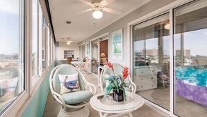 A balcony with wicker chairs, a small table, and a view of the city. - 1200-406 - Standard Plus - Embrace Spectacular Water Views (Siesta Key)