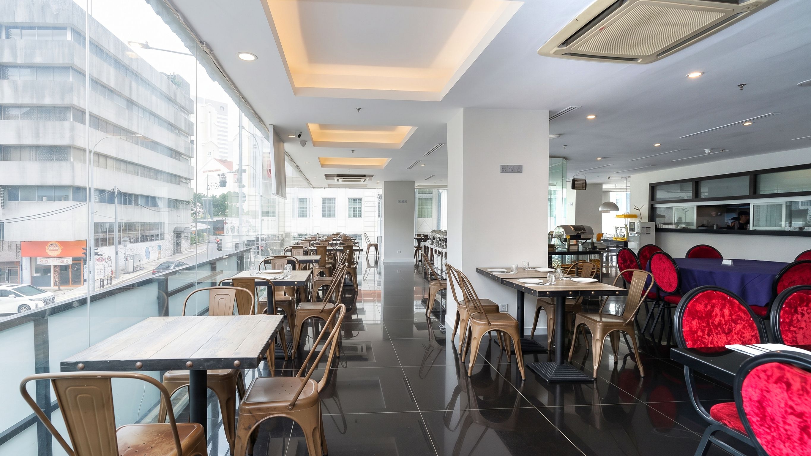 Een modern restaurant met een lange toonbank, meerdere tafels en stoelen.