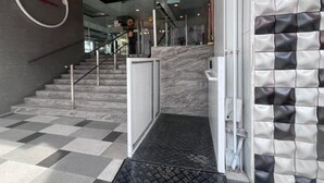 Una scala con pavimento a scacchi che conduce a una porta in vetro.