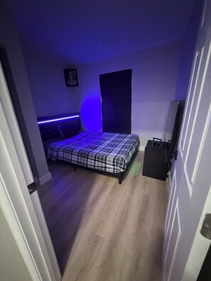 A bedroom with a bed, a dresser, and a door.