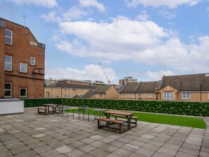 A courtyard with outdoor seating and a brick building. - Hoxton Residence by Interhome (Hoxton)