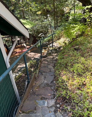 A stone staircase leading to a covered outdoor area with chairs and tables. - Peaceful 1-bedroom studio cabin in enchanting Cazadero, a waterfall getaway (Cazadero)