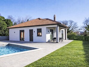 A modern house with a swimming pool, a covered patio, and a well-maintained lawn. - Charming 3-Bedroom Riviera by Interhome (Nedescina)