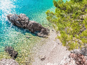 A rocky shoreline with clear turquoise water and sparse vegetation. - Charming 3-Bedroom Riviera by Interhome (Nedescina)