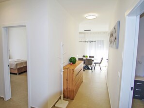 A hotel room with a bed, a wooden dresser, a small table with chairs, and a window with curtains. - Charming 3-Bedroom Riviera by Interhome (Nedescina)