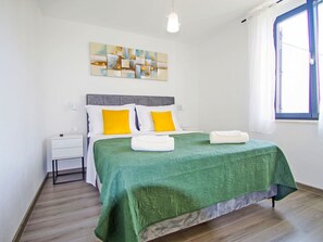 A hotel room with a bed, a nightstand, a window, and a painting on the wall. - Stara Hiža by Interhome (Valbandon)