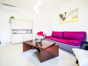 Una sala de estar moderna con una mesa de centro de madera, un sofá rojo y una silla blanca.