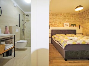 Ein Badezimmer mit Dusche, Toilette und einem Handtuchregal.