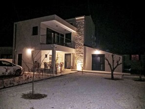 Um edifício moderno de dois andares com varanda e entrada para carros.