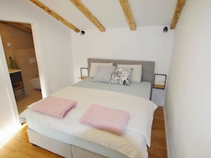A bedroom with a bed, two pillows, a bedside table, and a nightstand. - Poli Nona by Interhome (Valbandon)