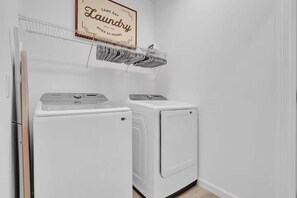 A laundry room with two white washing machines and a hanging rack above. - 15-Suite Luxury Villa | Sleeps 32 | Private Pool (Kissimmee)