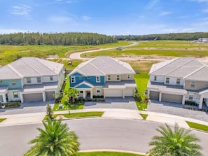 A residential area with modern houses, a curved driveway, and a clear sky. - 15-Suite Luxury Villa | Sleeps 32 | Private Pool (Kissimmee)