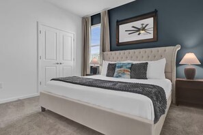A bedroom with a large bed, a ceiling fan, a framed picture on the wall, and a window with curtains. - 15BR Sonoma Resort Home in Kissimmee w/ Pool & Game Room (Kissimmee)