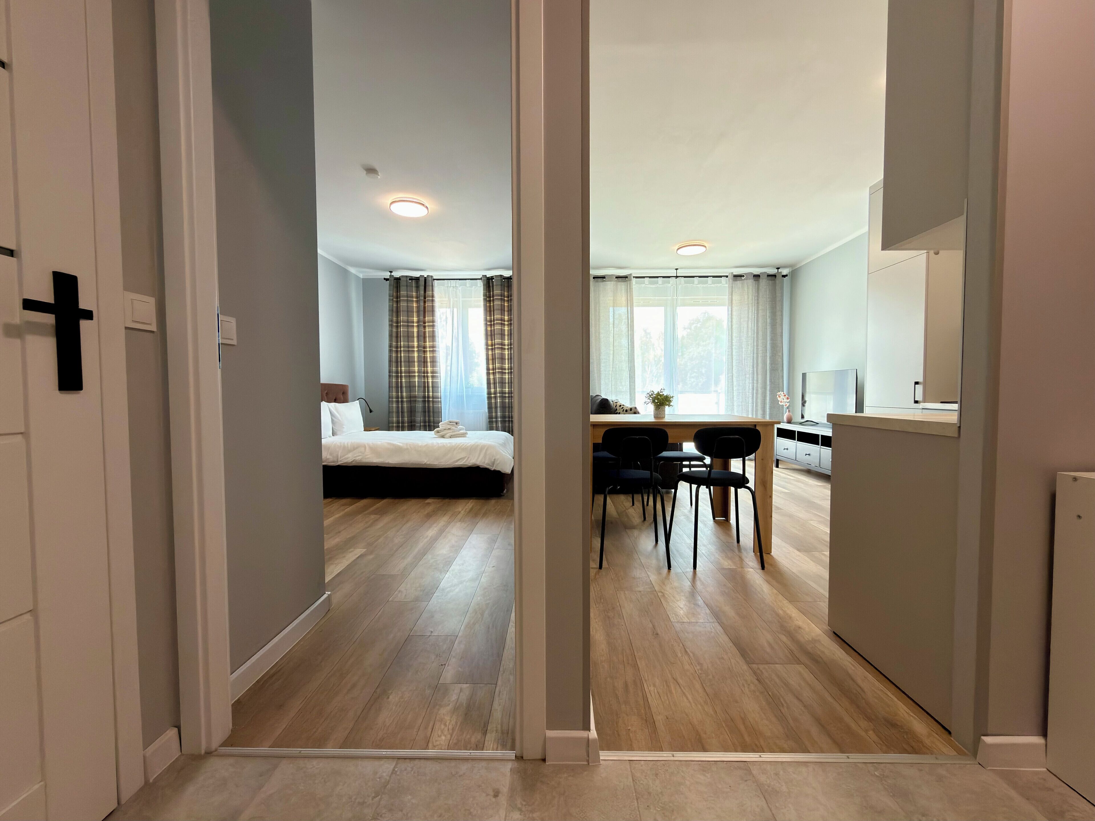 A hotel room with a bed, a desk, and a dining area.