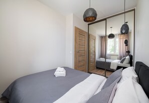 Une chambre moderne avec un grand lit, une armoire et un miroir.