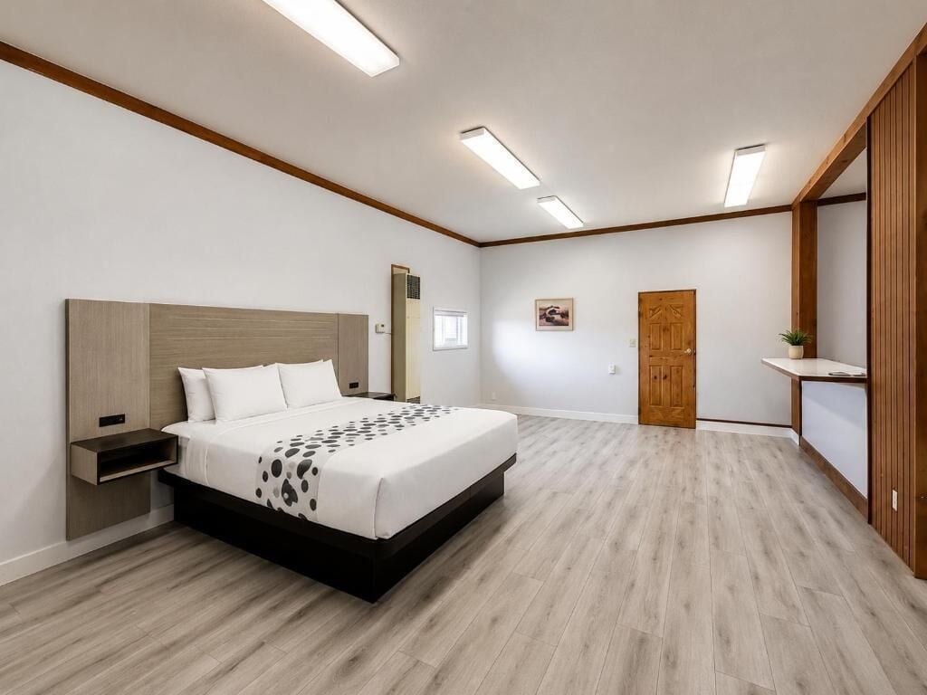 A bedroom with a bed, bedside table, and a wooden wardrobe.