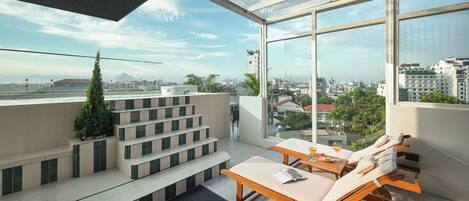 Un balcón moderno con cerramiento de vidrio, con vistas a la ciudad.