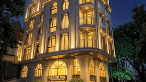 A multi-story hotel with a grand entrance, large windows, and a crescent moon in the background. - Grand Sol Luxury Boutique Hotel (Hanoi)