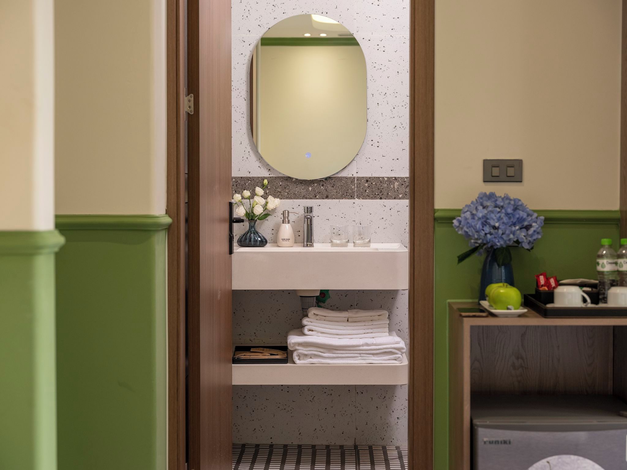 Un bagno con specchio, lavabo e portasciugamani.