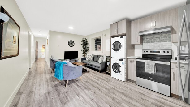 A modern kitchen with a built-in oven and a washing machine.