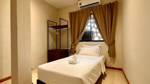 Una habitación de hotel con cama, ventana con cortinas, aire acondicionado y un espejo.