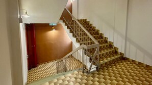 Una escalera con suelo de diseño geométrico y barandilla metálica.